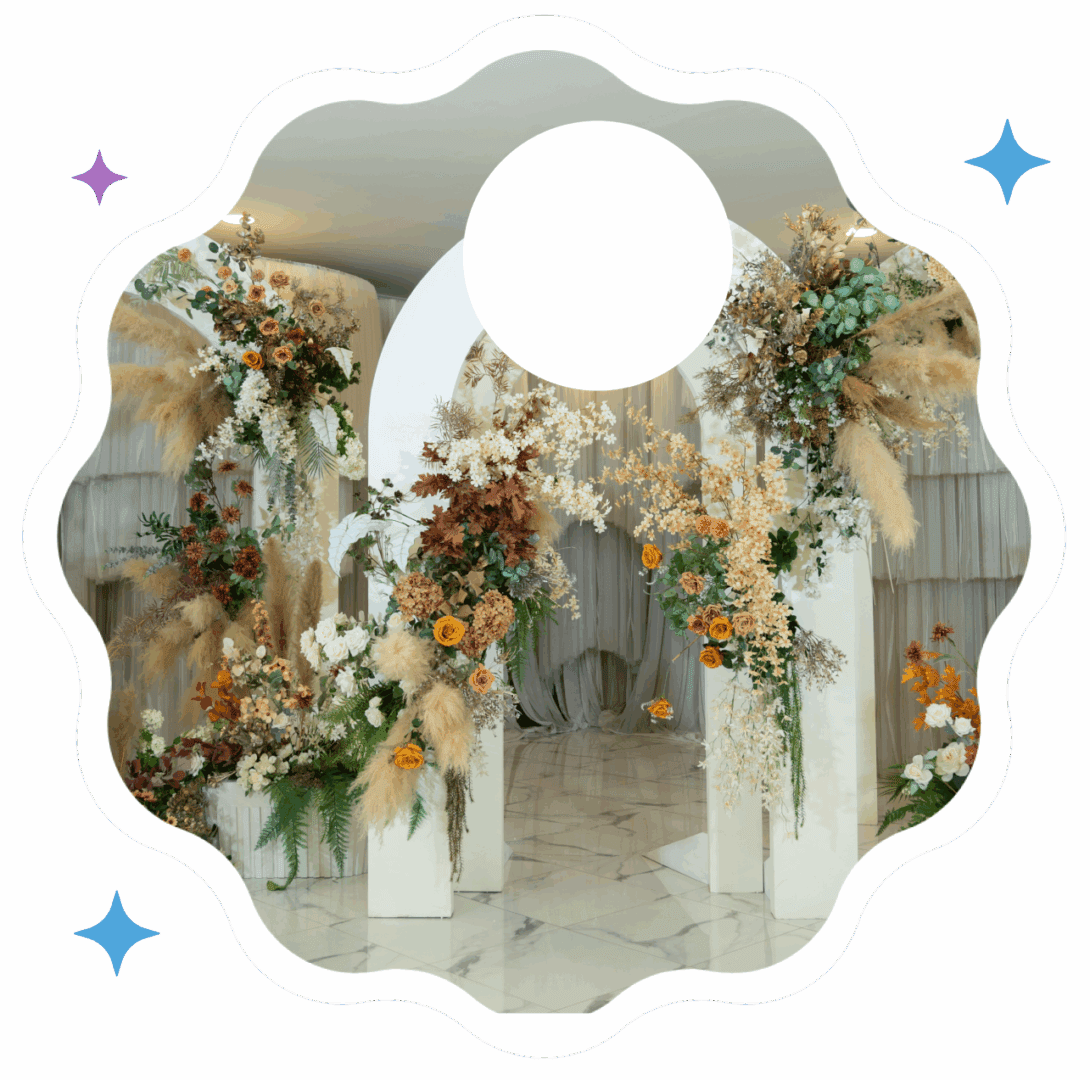 Floral archway decoration with white drapes and autumn-colored flowers.